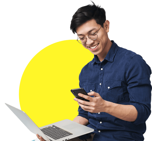 happy man looking at phone with laptop